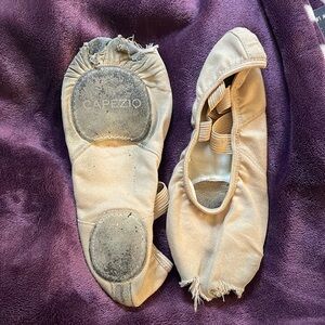 Used Capezio ballet flat shoes. Very worn condition, holes in the toes, tan.